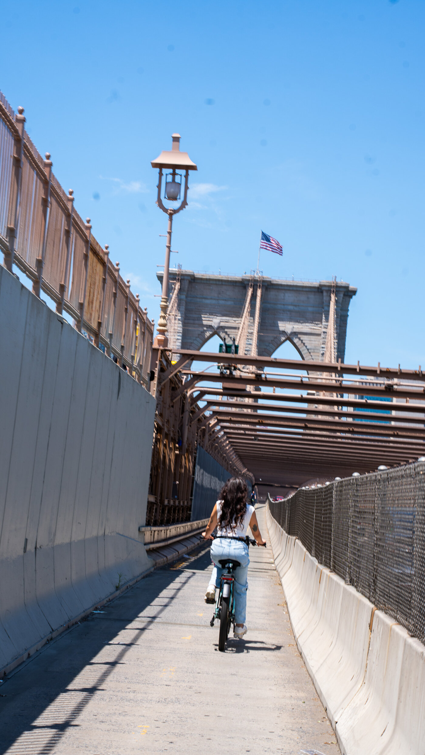 Customer riding a Velotric e-bike across the Brooklyn Bridge — historic NYC bike ride from Midtown